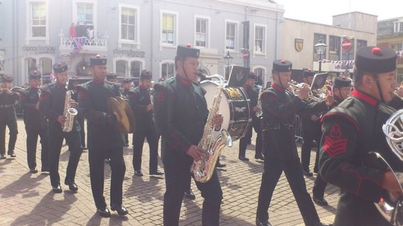 A brass band heralds the arrival of the royal party
