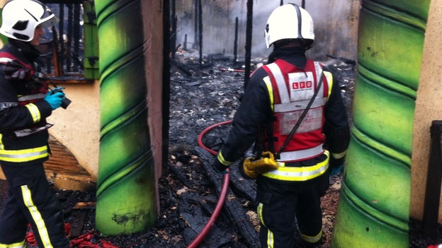 Firefighters access the damage by this morning's blaze.