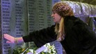 A woman touches the wall of remembrance at Dryfesdale Cemetery in Lockerbie