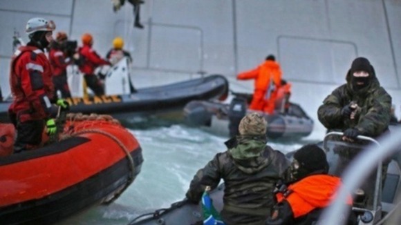 Greenpeace said their protesters were threatened with knives and guns