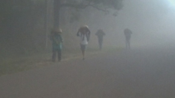 People walking on road as they attempt to protect themselves from the volcanic ash