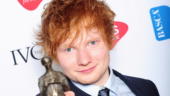 Ed Sheeran shows off his prize at London's Grosvenor House Hotel.