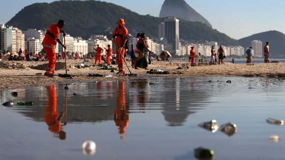 Workers clean the beach of Copacabana after New Year's celebrations - but how clean is the water?
