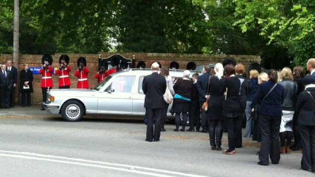Soldiers firing a 12 gun salute at the end of the funeral of Guardsman Michael Roland
