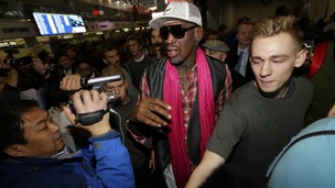 Dennis Rodman (C) is surrounded by journalists as he arrives at the Beijing Capital International Airport to leave for Pyongyang