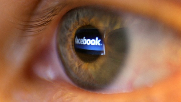 A woman reads facebook on a screen.