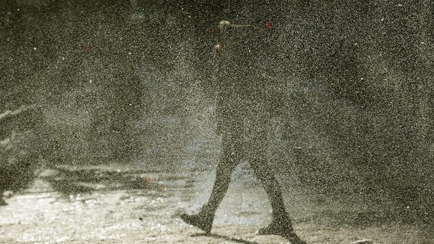 A woman walks through a gust of blowing snow in frigid cold temperatures though downtown Chicago, Illinois