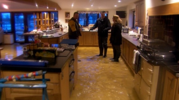 Mike and Jenny Curtis, whose house has flooded for the second time in as many years, show me around