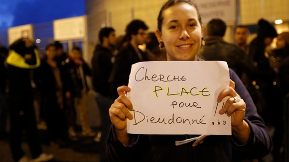 A woman holds a hand-made sign outside the Nantes concert venue.