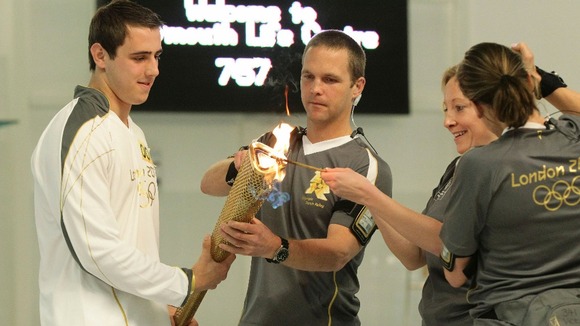 Jordan Anderton holds the torch as it is lit at the start of Day 2 of the Olympic Torch Relay, at the Life Centre in Plymouth