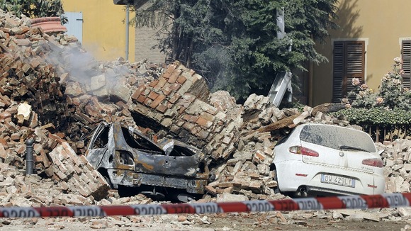 Destroyed cars are seen in the rubble after an earthquake in Finale Emilia