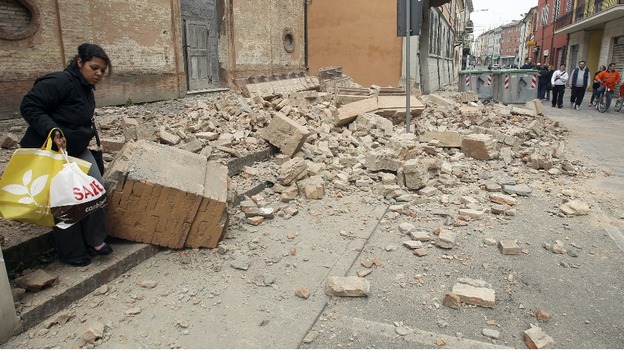A woman carries belongings from her home after the earthquake in Finale Emilia, Italy