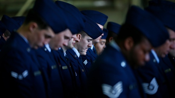 Service personnel pray during the memorial service