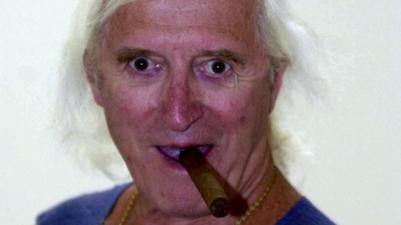 Jimmy Savile with a cigar in his mouth.