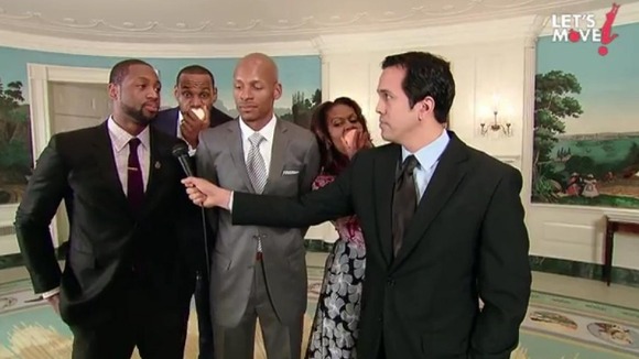 Michelle Obama and LeBron James (second from L) munch on apples in the background