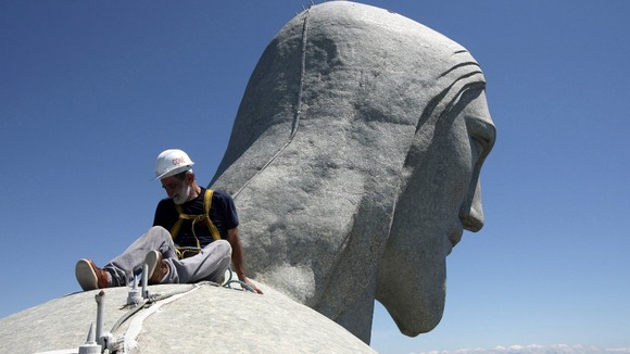 A worker inspects the Christ the Redeemer statue