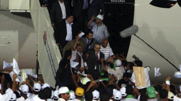 Abdelbasset al Megrahi walks down the stairs upon his arrival at airport in Tripoli August 20, 2009