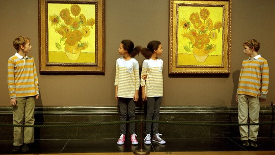 Two sets of twins stand next to the pair of sunflower paintings created by Vincent Van Gogh