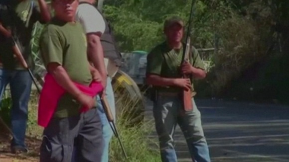 Armed men on the side of a road in Mexico.