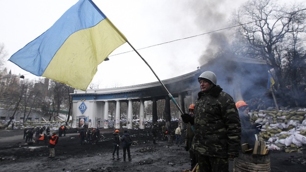 An anti-government protester waves a Ukranian flag