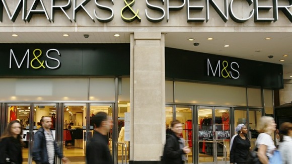 Pedestrians pass a Marks and Spencer store, in central London