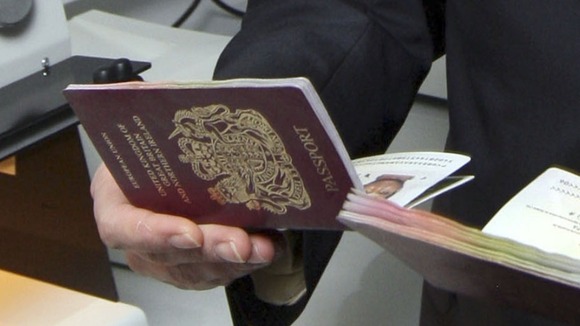A British passport held in a hand.