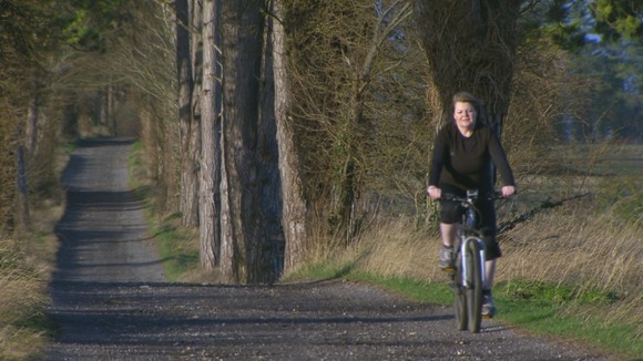 woman on bicycle on country lane