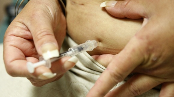 A women with diabetes injects herself with insulin