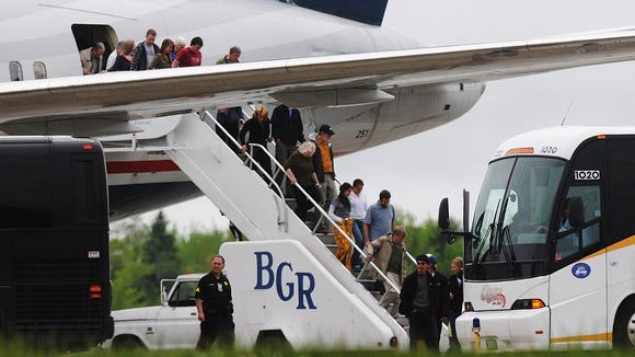 Passengers de-plane a trans-atlantic flight originating in France on the tarmac at Bangor International Airport