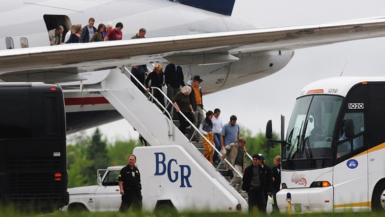 Passengers de-plane a trans-atlantic flight originating in France on the tarmac at Bangor International Airport