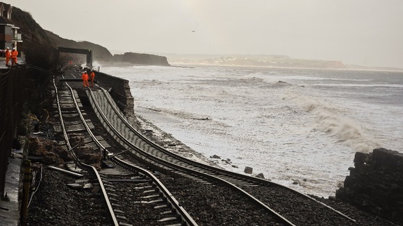 A huge length of railway track is exposed and left hanging after the sea wall collapsed in Dawlish