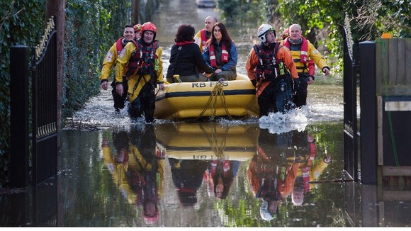 Members of the Royal Berkshire Fire Service rescue residents whose houses have been flooded in Staines-upon-Thames