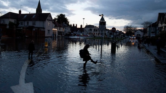 A child plays in the water in the centre of Datchet, Berkshire