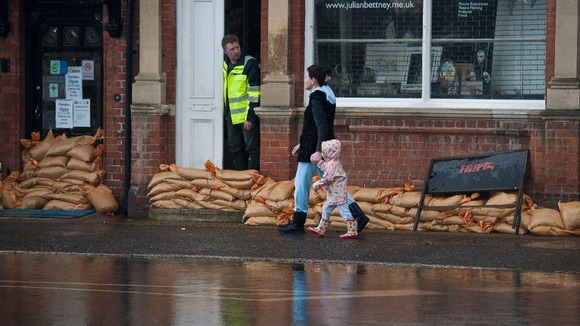 Residents walks through the village centre following flooding in Datchet, Berkshire