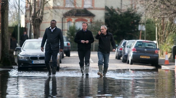 David Cameron with a local and Kwasi Kwarteng (left), the MP for Spelthorne, on a flooded street in Staines-upon-Thames.