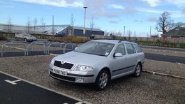 Silver Skoda car parked.