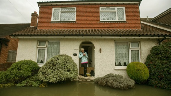 Nikki Vipers from Egham, Surrey looks at the flooded garden of her parent's home in Egham, Surrey.