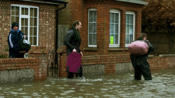 Members of the army carry belongings to higher ground in Egham, Surrey.