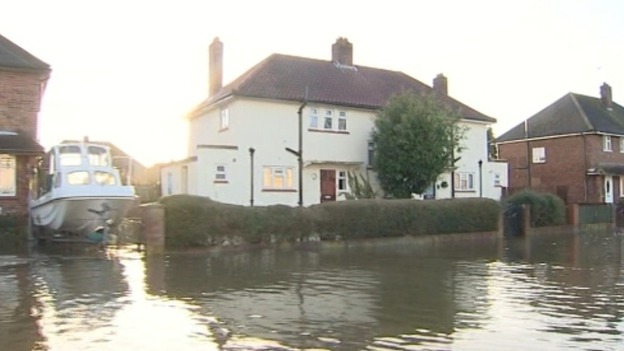 A boat rests out of the water next to houses in Egham Surrey.