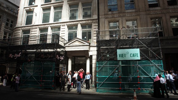 A temporary scaffolding sun shade on the street below the building