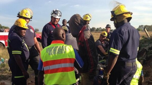 Emergency services at the scene of an abandoned shaft where 30 "illegal miners" were trapped.