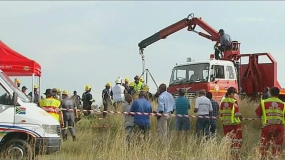 Emergency services at the scene of an abandoned shaft where 30 "illegal miners" were trapped.