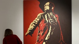 A visitor looks at a painting of South Africa's President Jacob Zuma at an exhibition in Johannesburg before it was defaced