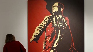 A visitor looks at a painting of South Africa's President Jacob Zuma at an exhibition in Johannesburg before it was defaced