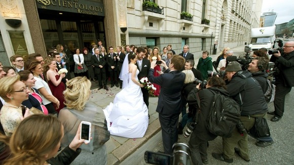 The couple pose for the waiting media after taking their vows.