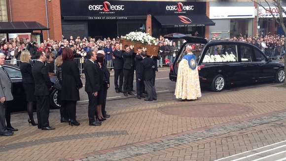 Players past and present carry the coffin as thousands watch on to say goodbye