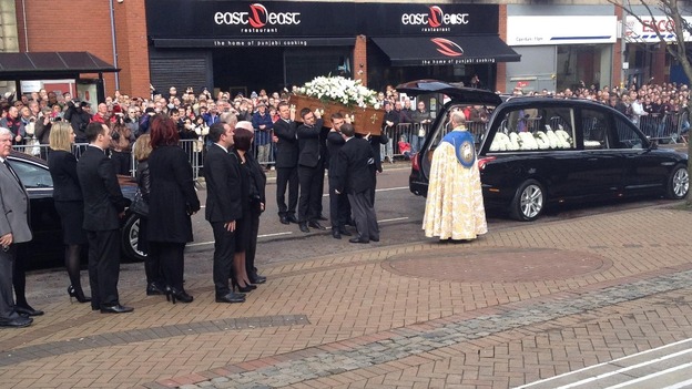 Players past and present carry the coffin as thousands watch on to say goodbye