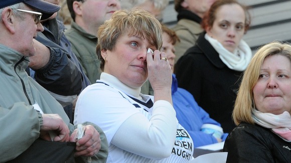 A woman in a Preston North End shirt appears tearful as the service is shown