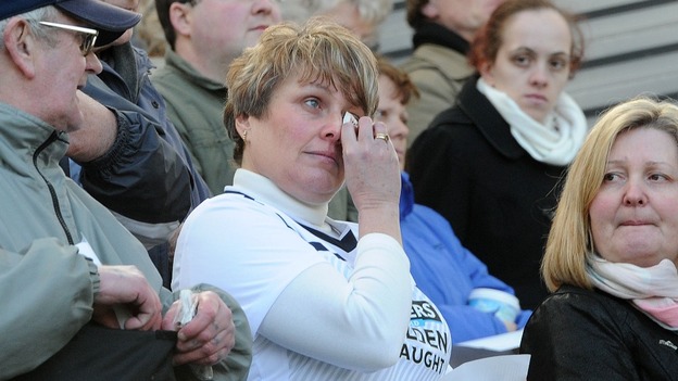 A woman in a Preston North End shirt appears tearful as the service is shown