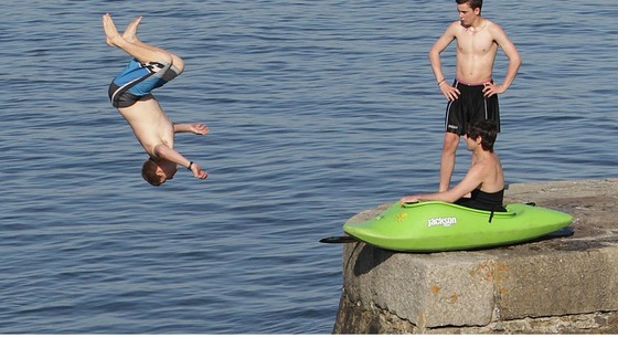 Young men jump into the water off a sea wall at Bray, Co. Dublin as the warm weather continues across Ireland